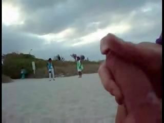 Americano turista segarsi su il spiaggia mentre donna passing da clip