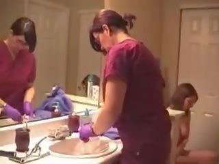 Ibu dan muda perempuan memasukkan cairan ke anus